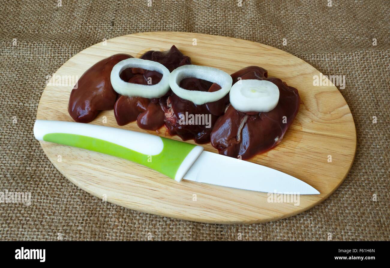 chicken liver with onions on a cutting board and knife Stock Photo