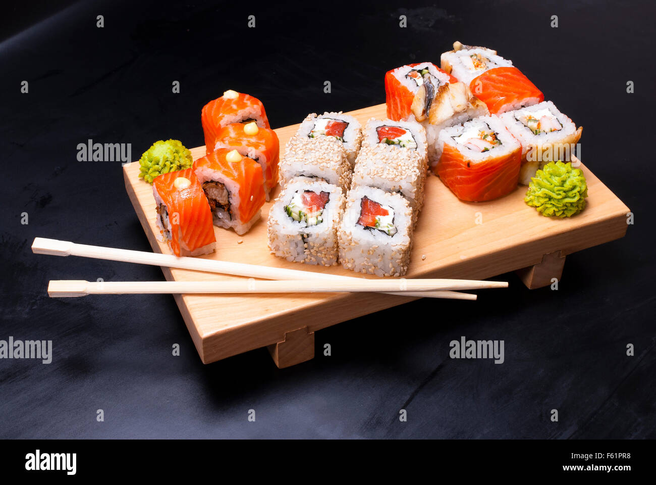 Sushi roll set the board on a black background Stock Photo