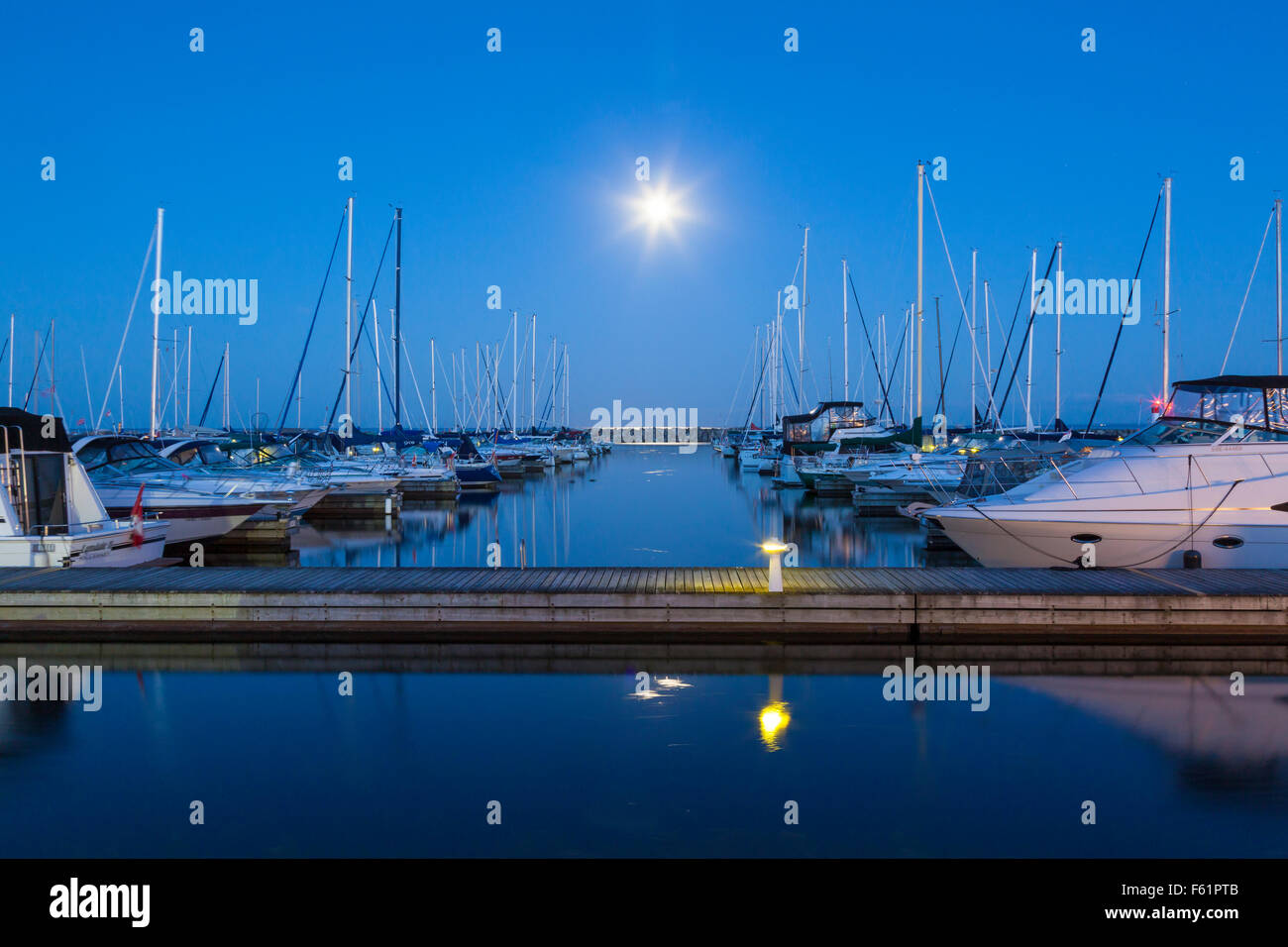 Yachts at the Bronte Outer Harbour Marina at dusk during a full moon