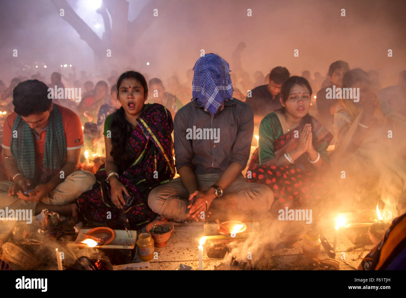 Naryanganj, Bangladesh. 10th Nov, 2015. Hindu devotees observe 3rd day of Rakher Upobash at 'Baba Loknath Ashrom', Barodi. Every year thousands of Hindu devotees gather in front of Shri Shri Lokenath Brahmachari Ashram temple for the Kartik Brati or Rakher Upobash religious festival in Barodi, Near Dhaka, Bangladesh. Faithful sit in front of candles light ( named locally as Prodip ) and absorb in prayer. Credit:  Belal Hossain Rana/Pacific Press/Alamy Live News Stock Photo