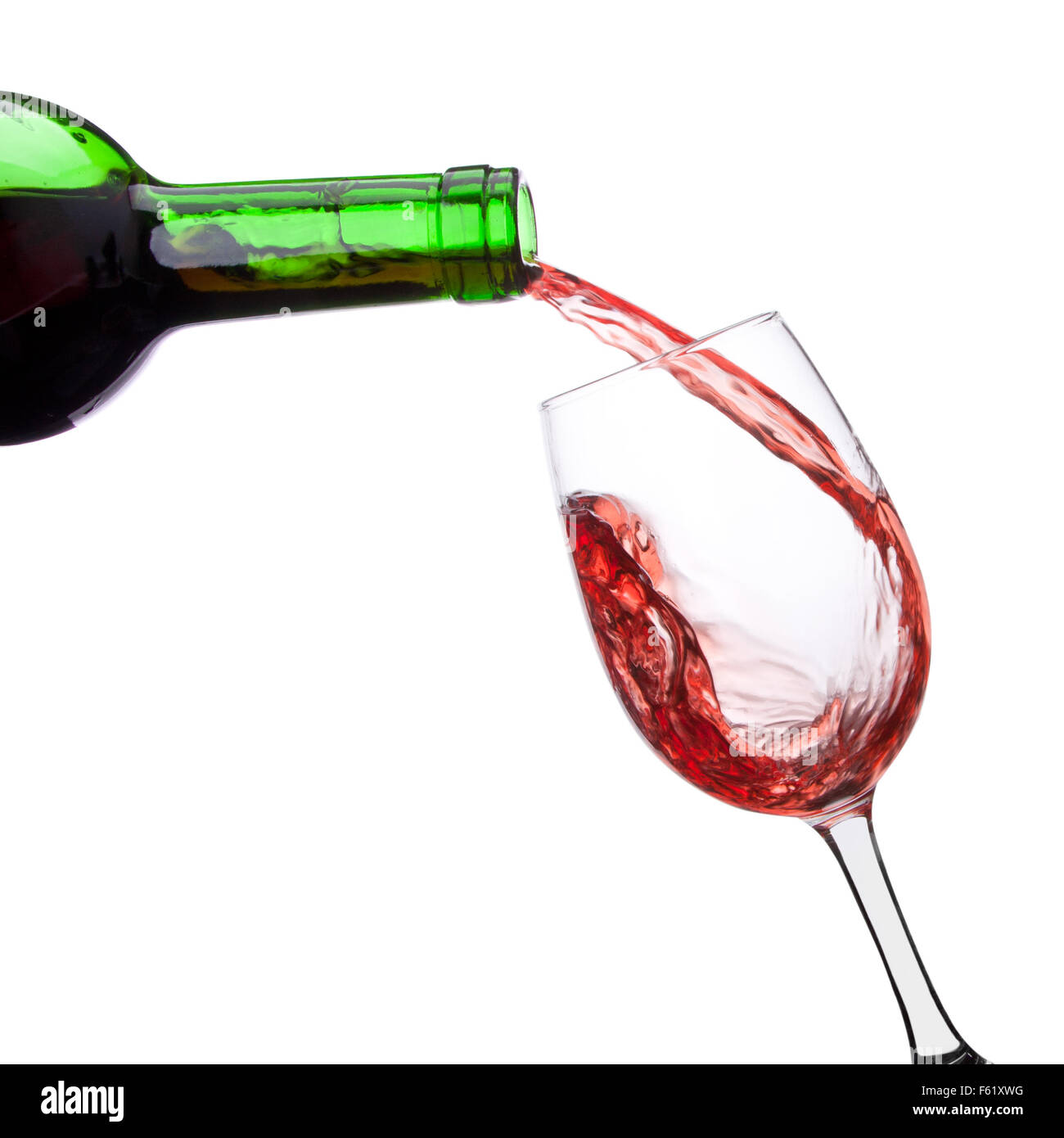 Red whine pouring into wineglass from bottle. Isolated Stock Photo