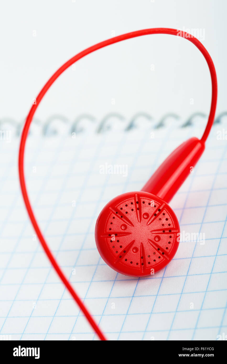 One red headphone over notebook Stock Photo
