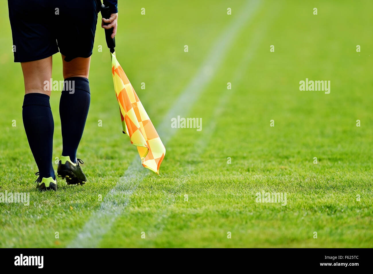 Assistant referee running along the sideline during a soccer match ...