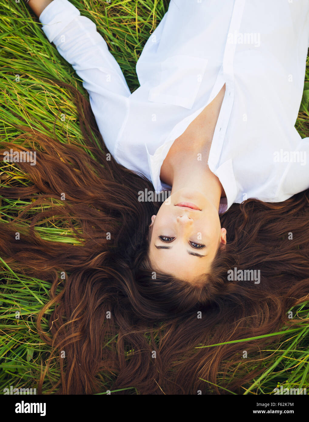 Beautiful Young Woman Relaxing Outdoors in Green Grass Stock Photo - Alamy
