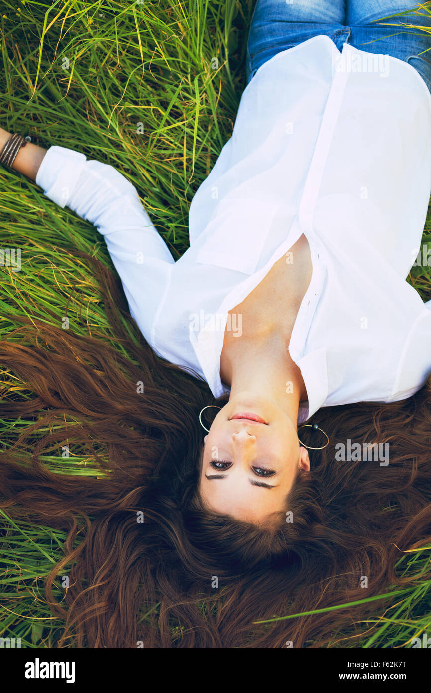 Beautiful Young Woman Relaxing Outdoors in Green Grass Stock Photo - Alamy