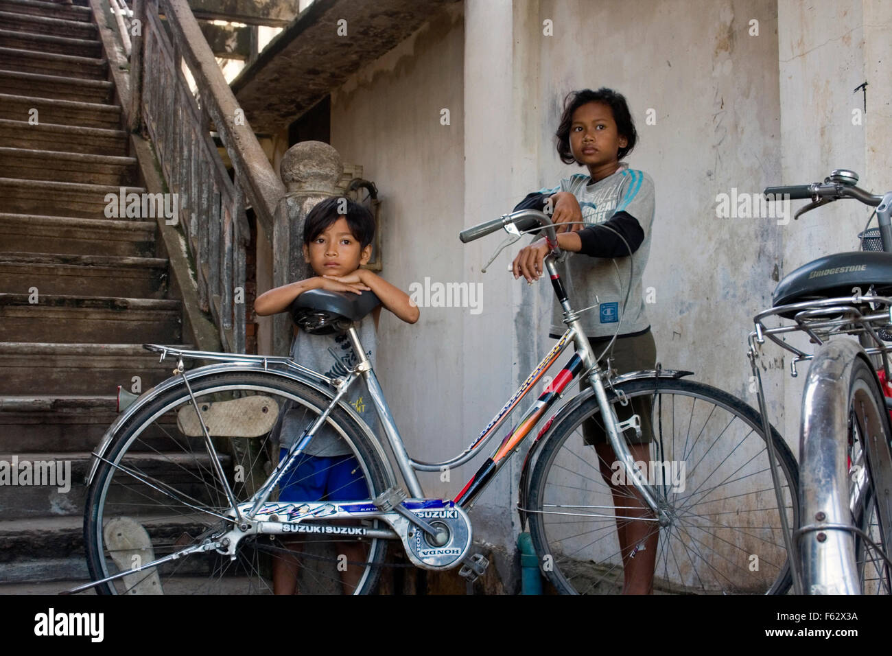 A young 14 year-old girl and an 11 year-old boy gaze in the distance at a slum in Kampong Cham, Cambodia. Stock Photo