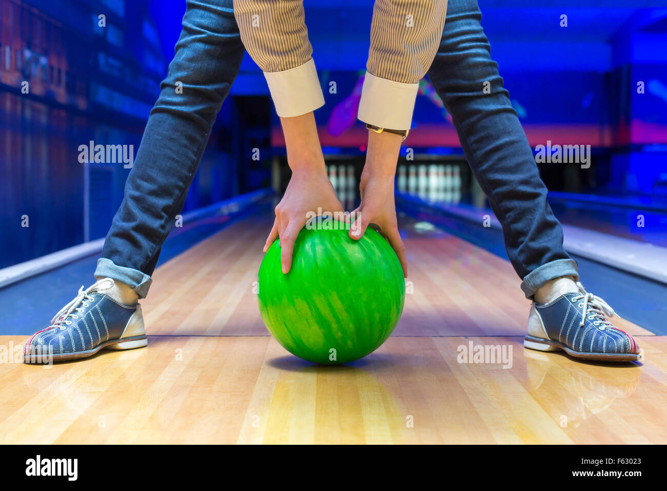 Funny beginner woman aiming to bowling pins Stock Photo