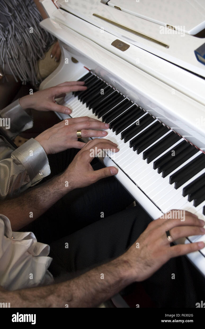 Playing the piano. Two pianists. Fingers at keypad Stock Photo
