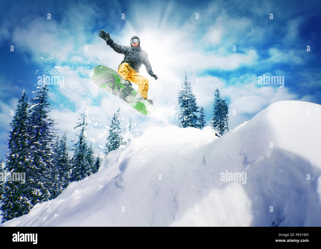 Snowboarder jump against sky and trees Stock Photo