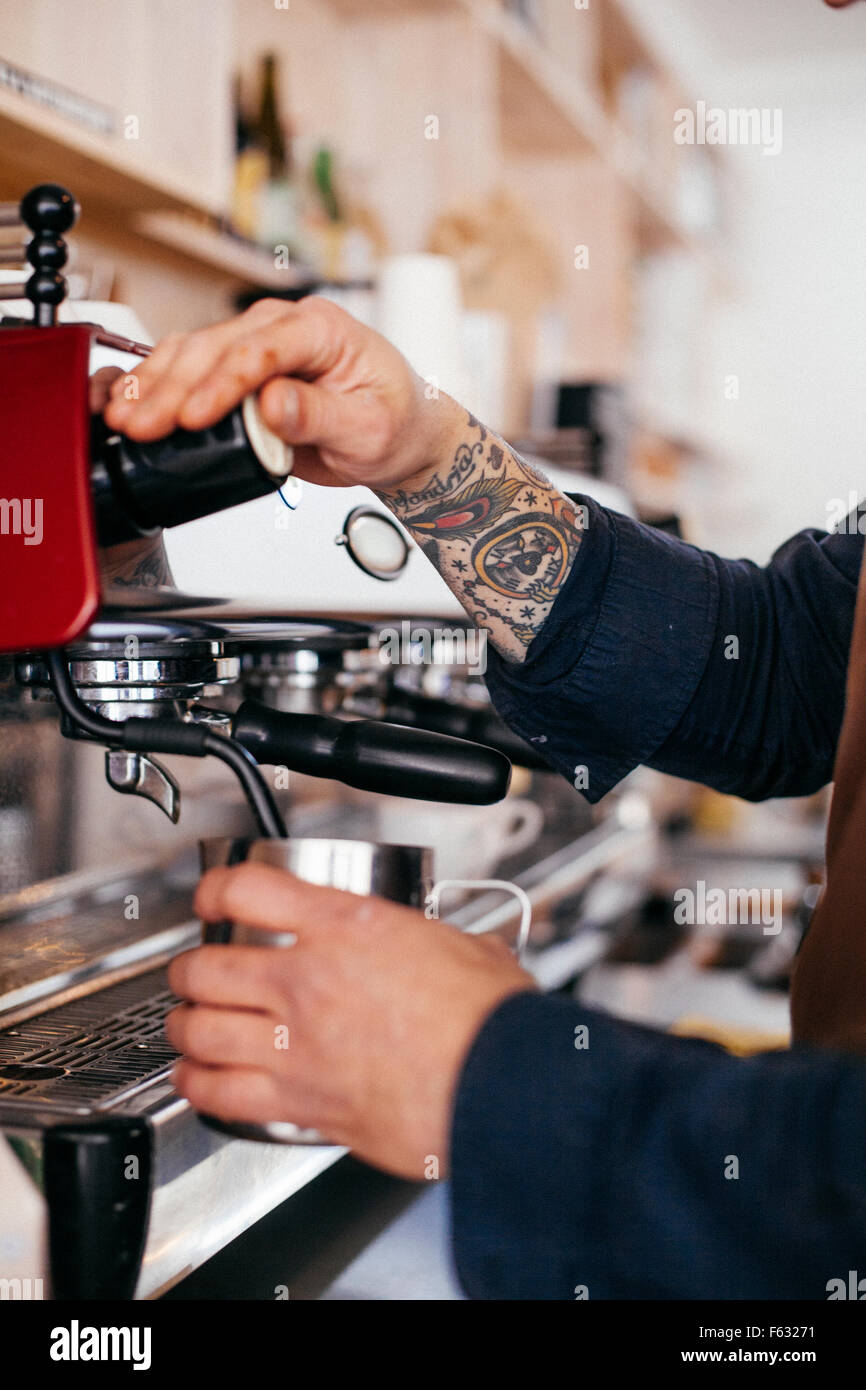 Cropped image of barista using coffee maker at cafeteria Stock Photo