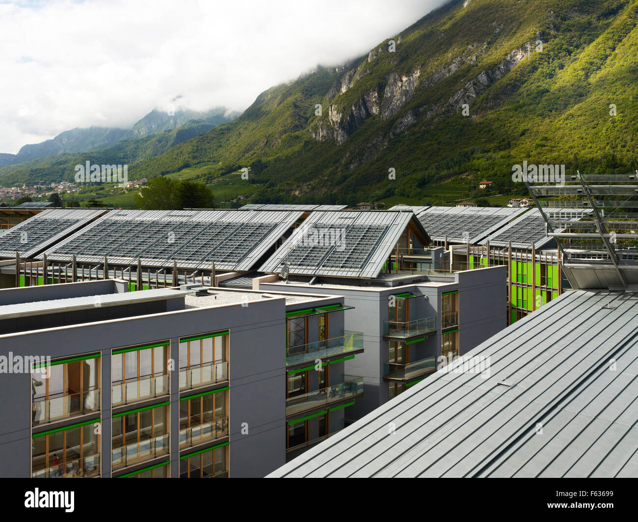 Roofscape with photovoltaic panelling and mountain range beyond. MUSE Science Museum, Trentino, Italy. Architect: Renzo Piano Bu Stock Photo