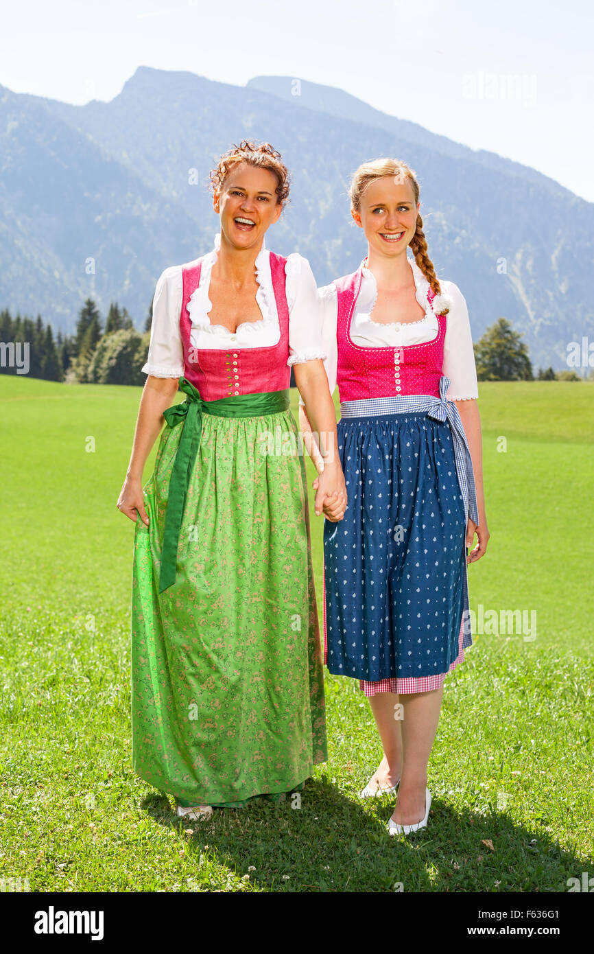 Mother and daughter walking both go hand in hand in a dirndl. Stock Photo