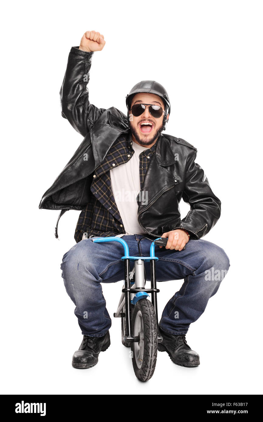 Vertical shot of an excited male motorcyclist riding a tiny bicycle and gesturing happiness isolated on white background Stock Photo