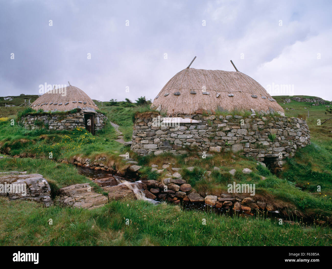 Looking SW across stream to a restored horizontal watermill (R) & kiln house (L) used to dry damp grain before milling. Shawbost, Isle of Lewis. Stock Photo