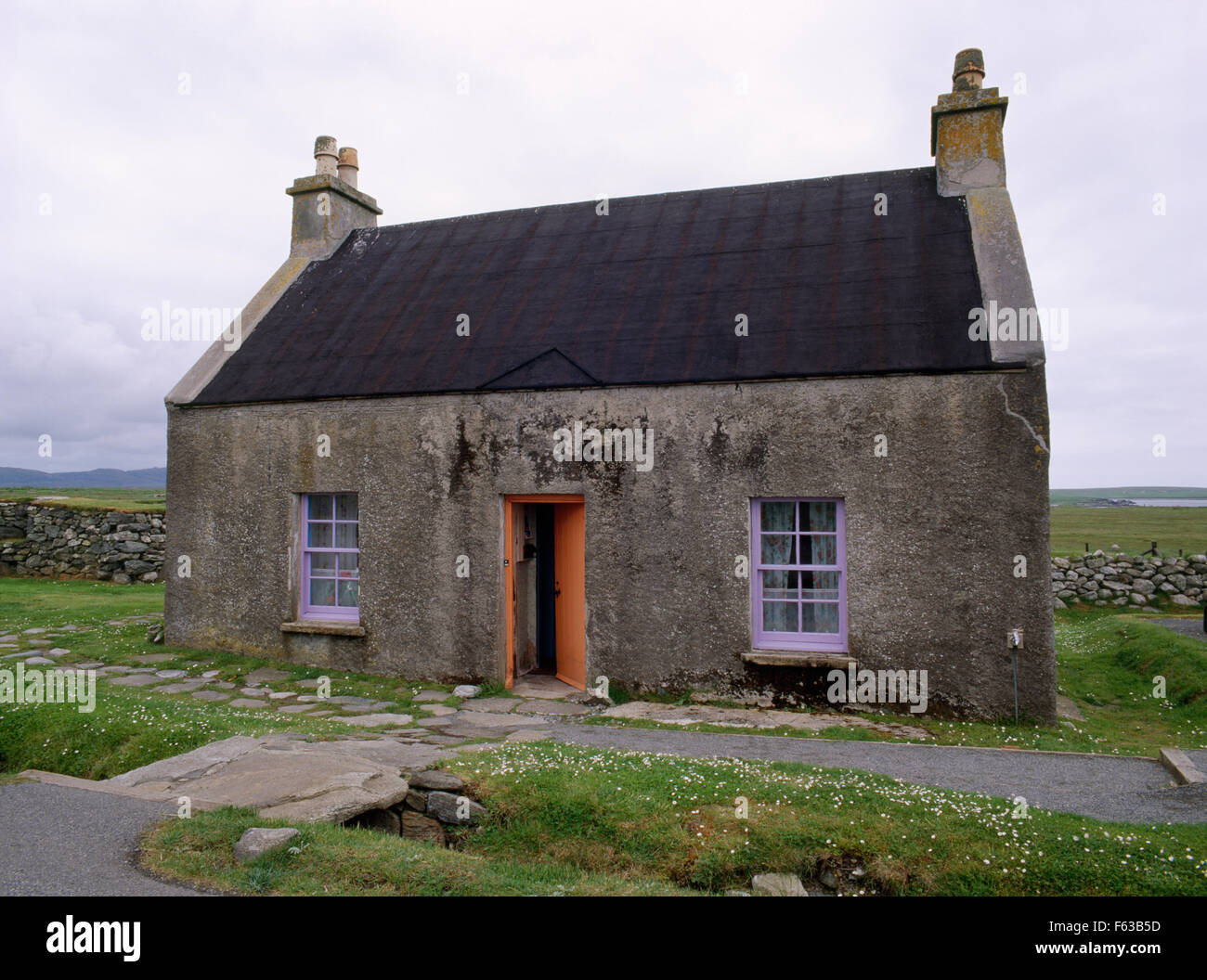 A 1920s croft house (whitehouse, tigh geal) across road from Arnol blackhouse, Lewis: single walled, lime-mortared, pebble dashed with tarred roof. Stock Photo