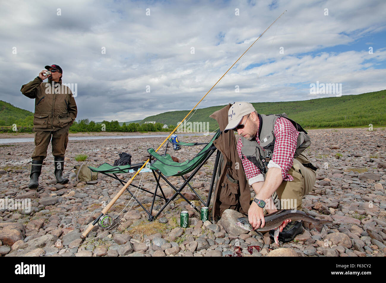 Fishing tourists with a small Atlantic salmon at Teno (Tana) River, on ...