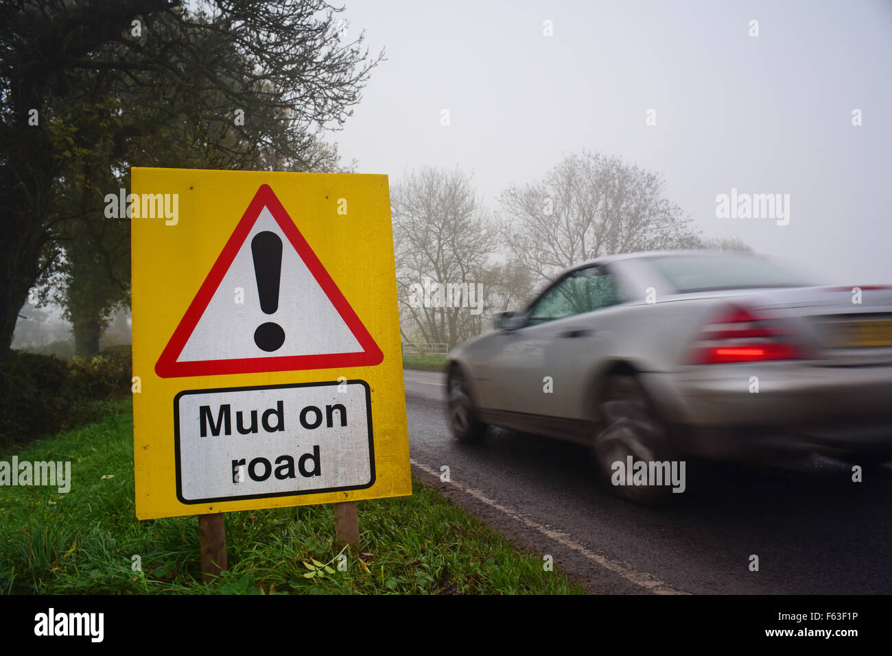 car passing mud on road ahead warning sign yorkshire united kingdom Stock Photo
