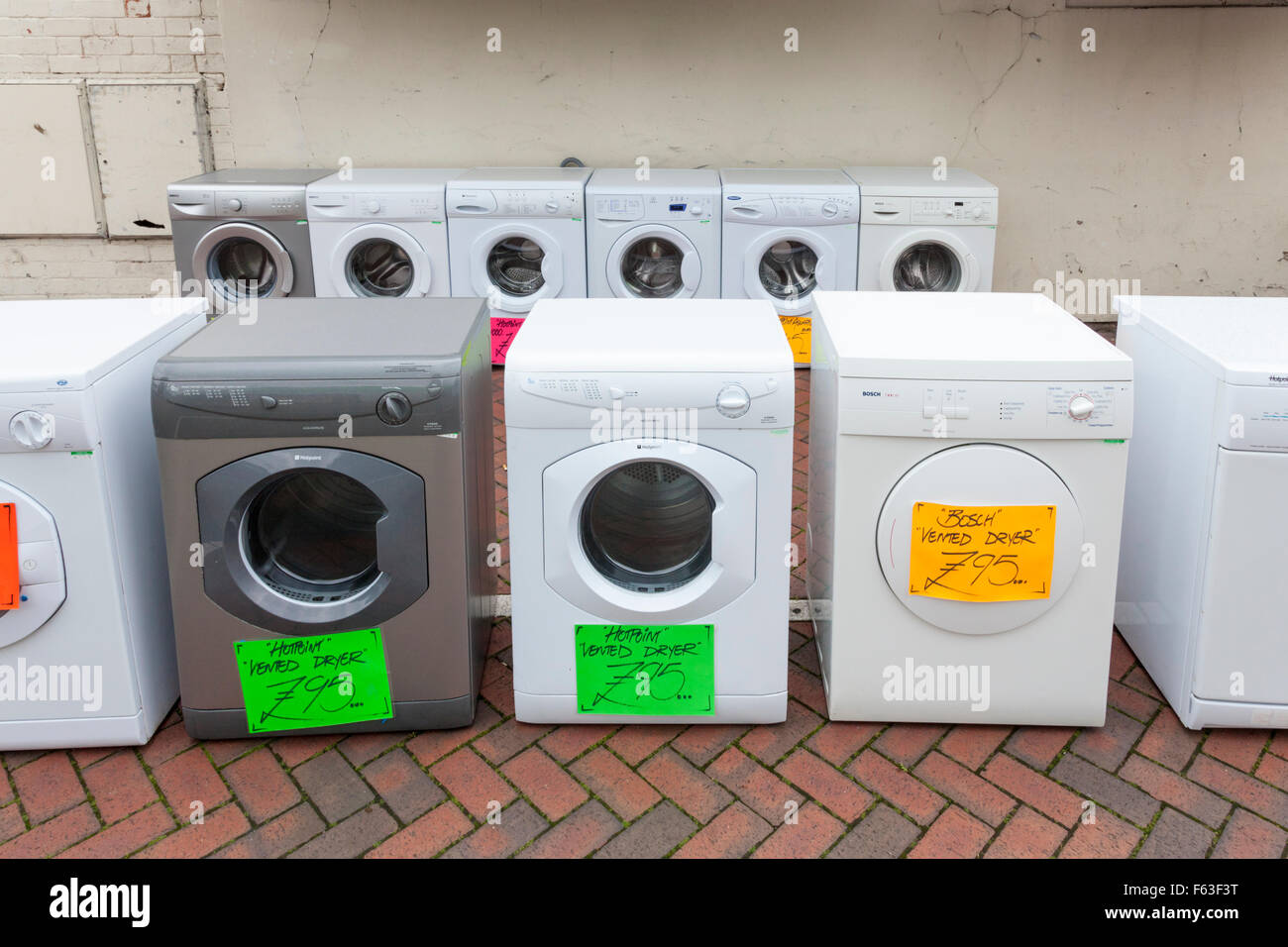 Old washing machines and second hand tumble dryers for sale on a UK town  centre street Stock Photo - Alamy