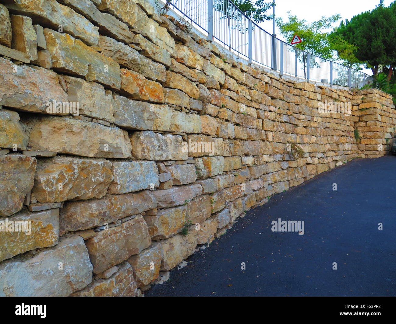 Retaining wall from granite blocks in residential street in Alora