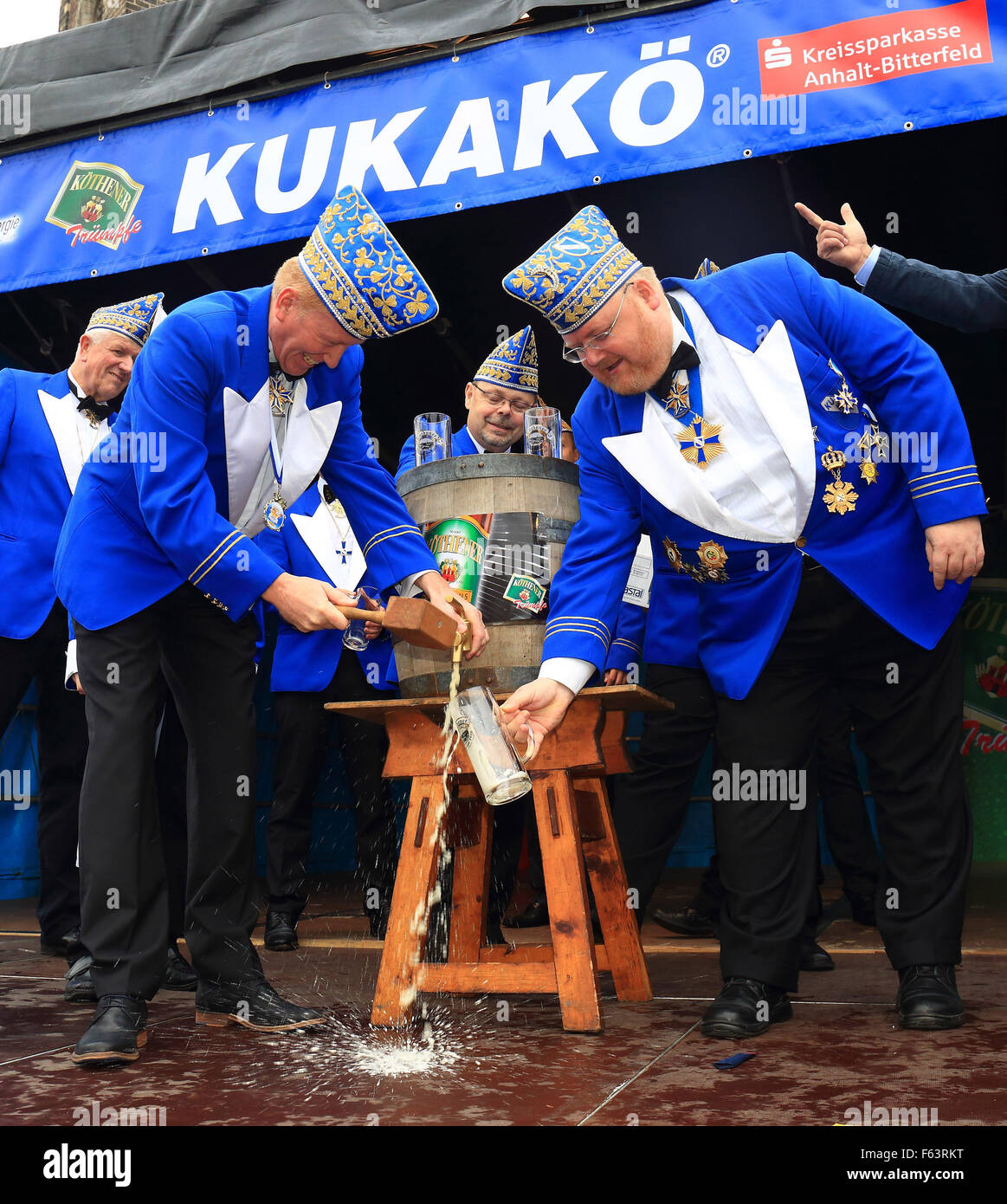 Koethen, Germany. 11th Nov, 2015. Ronald Mormann (R) and Michael Schoelzel from the 1st Koethen Carnival Society tap a keg of carnival beer in Koethen, Germany, 11 November 2015. As per tradition, carnival revelers took over the scepter of the city at 11:11. Photo: JENS WOLF/dpa/Alamy Live News Stock Photo