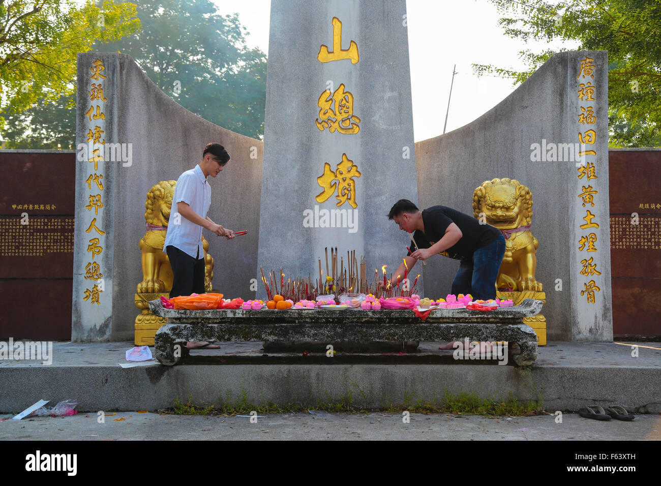 Chinese family give their offering to the main altar of Kwong Tong ...