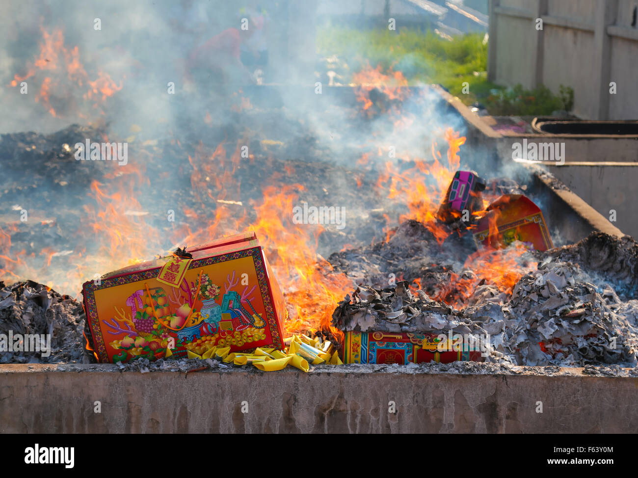 Chinese ancestor offerings burn in a public furnace at Kwong Tong