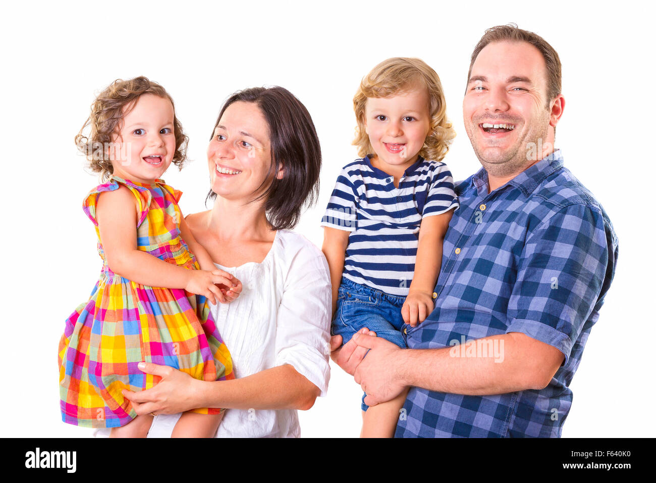 Happy family of four smiling while standing against white background. Stock Photo