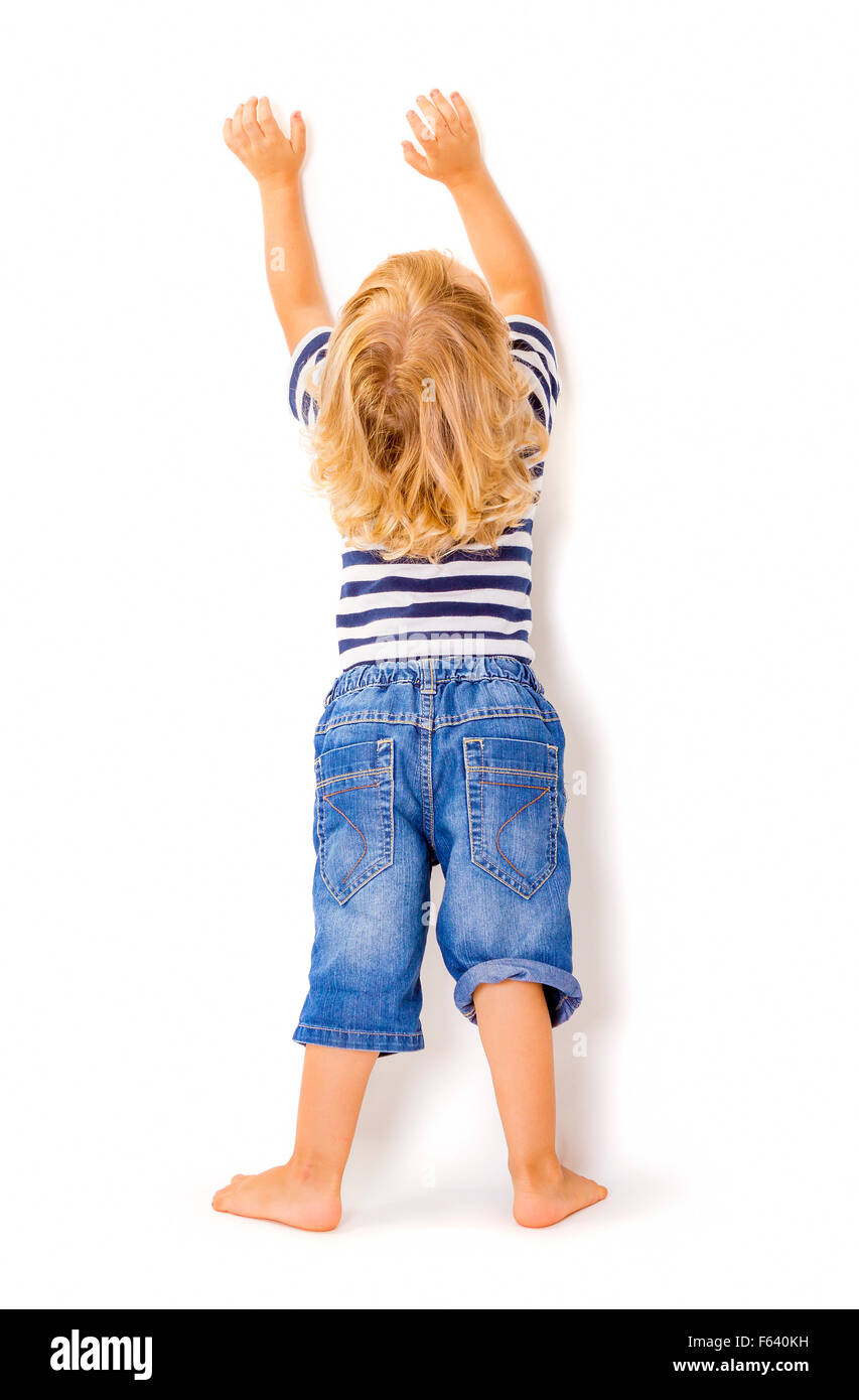 Back view of little boy with hands up on white background. Stock Photo