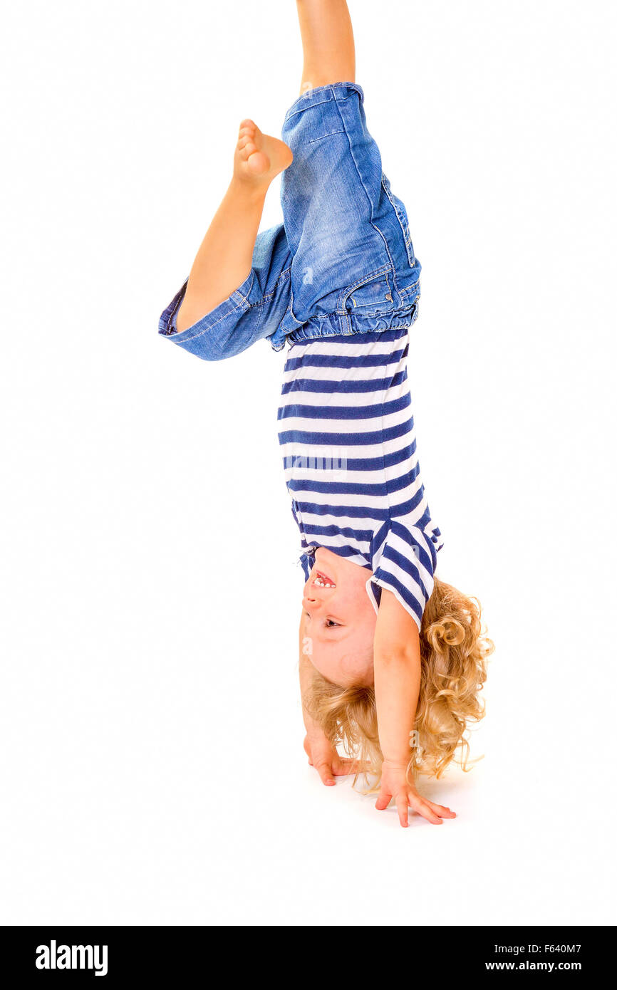 Happy little boy upside down on white background Stock Photo