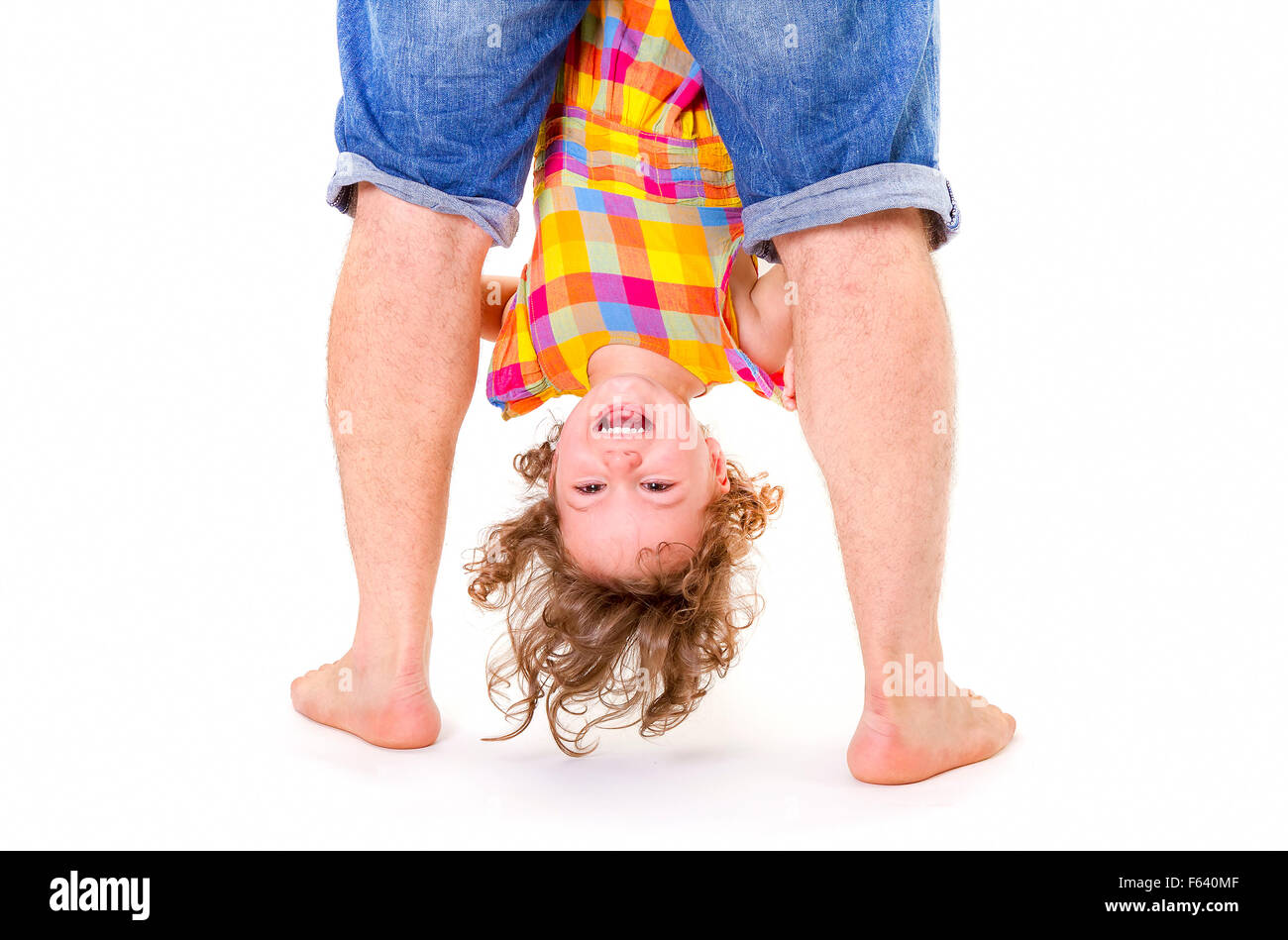 Father holding his little daughter upside down. Trust concept. Stock Photo