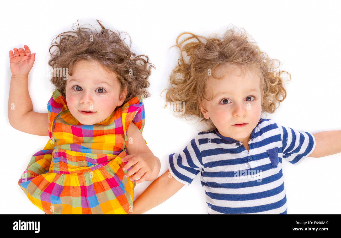 Little boy and girl looking at camera on white background Stock Photo