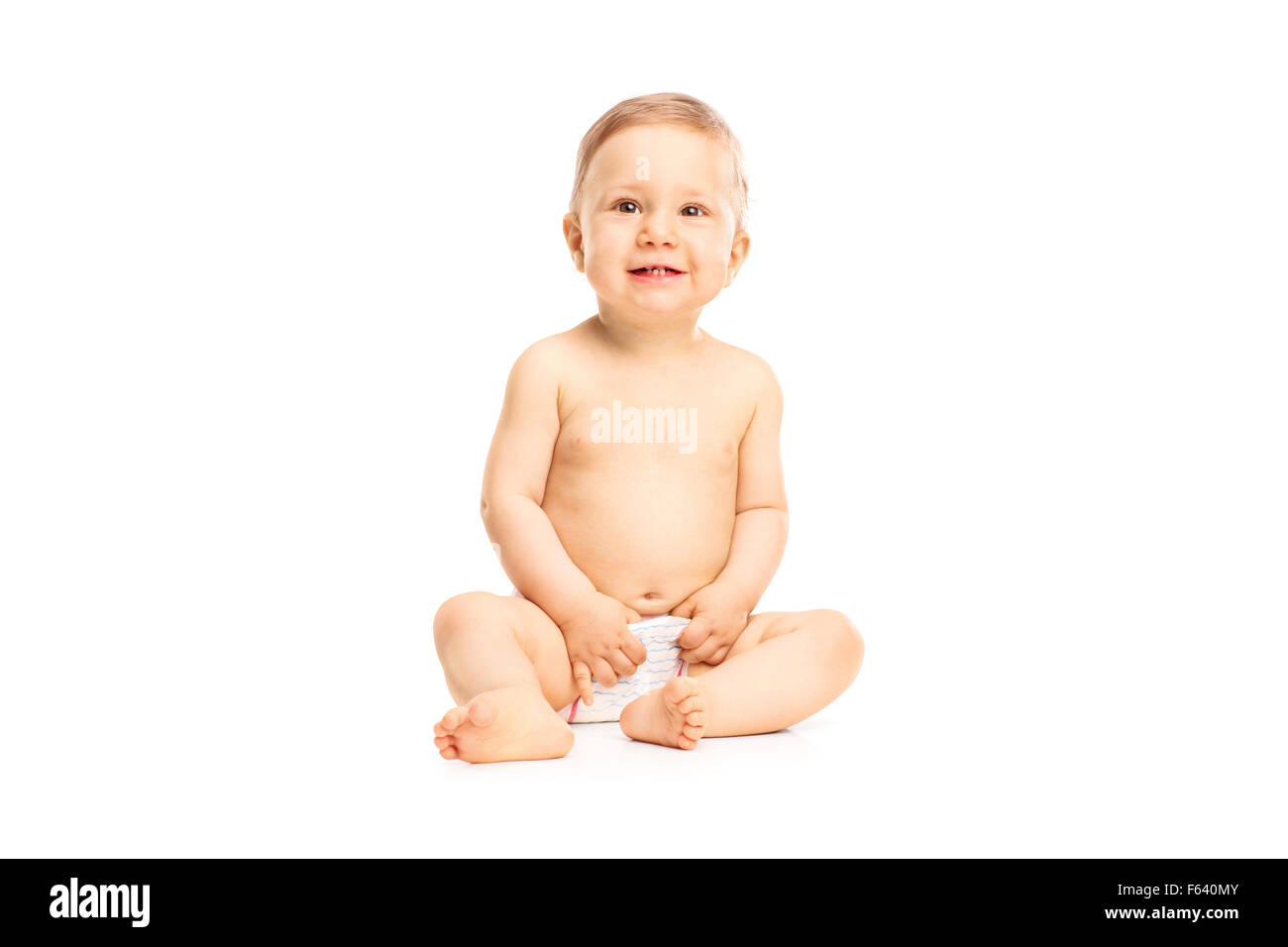 Studio shot of an adorable little baby girl in white diapers smiling and looking up isolated on white background Stock Photo