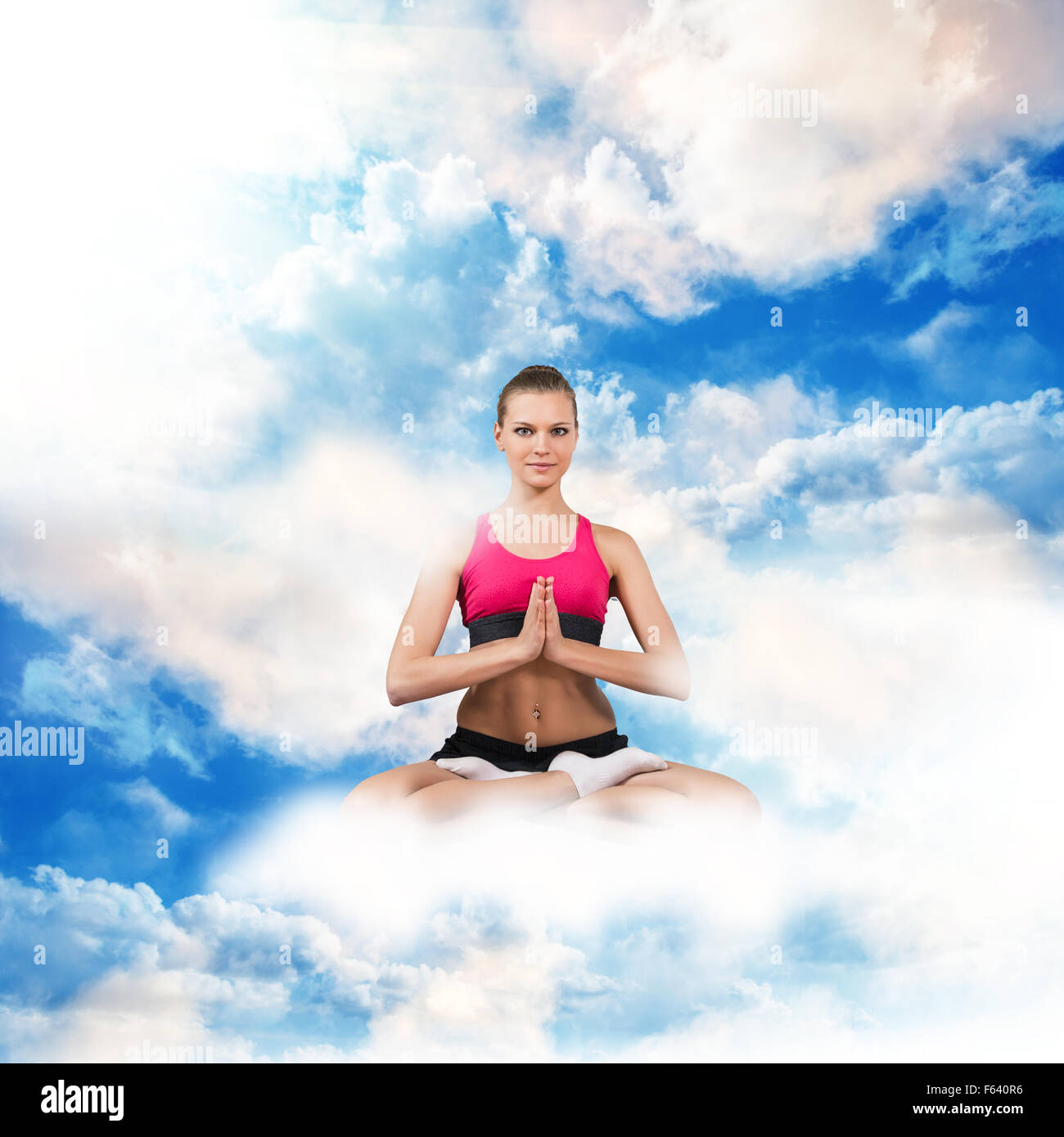 Woman sitting in lotus position on the clouds Stock Photo