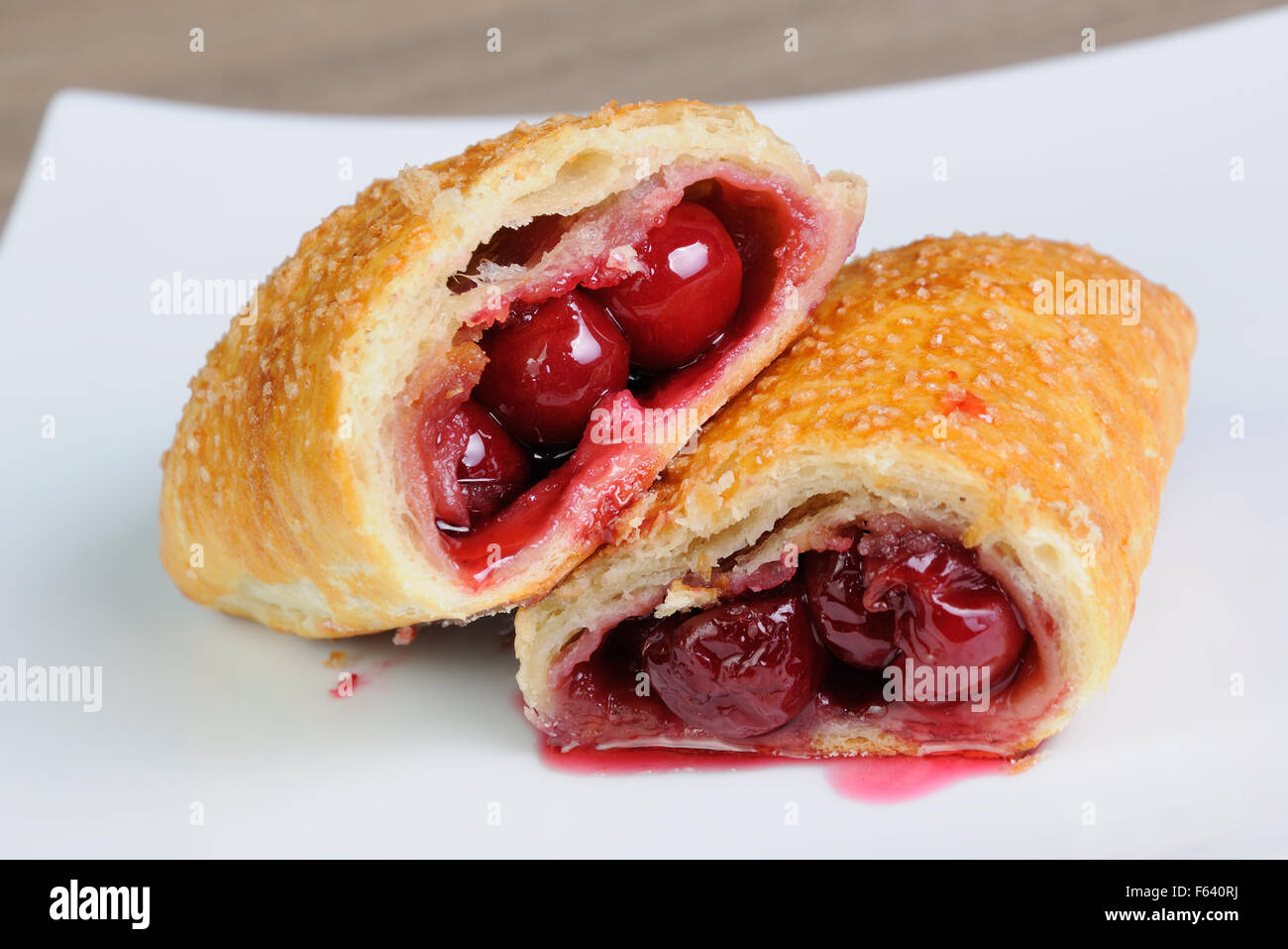 Bun puff pastry with cherry on the plate Stock Photo