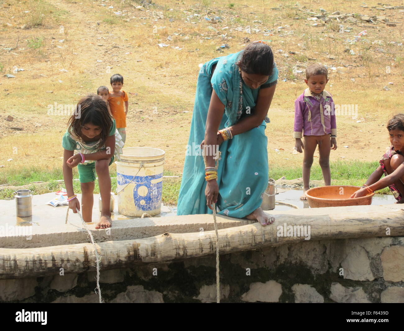 A woman with her daughter collects water at a well of the Tiger Reserve of  the National Park Panna in India, 25 October 2015. Photo: Friederike Heine/dpa  Stock Photo - Alamy