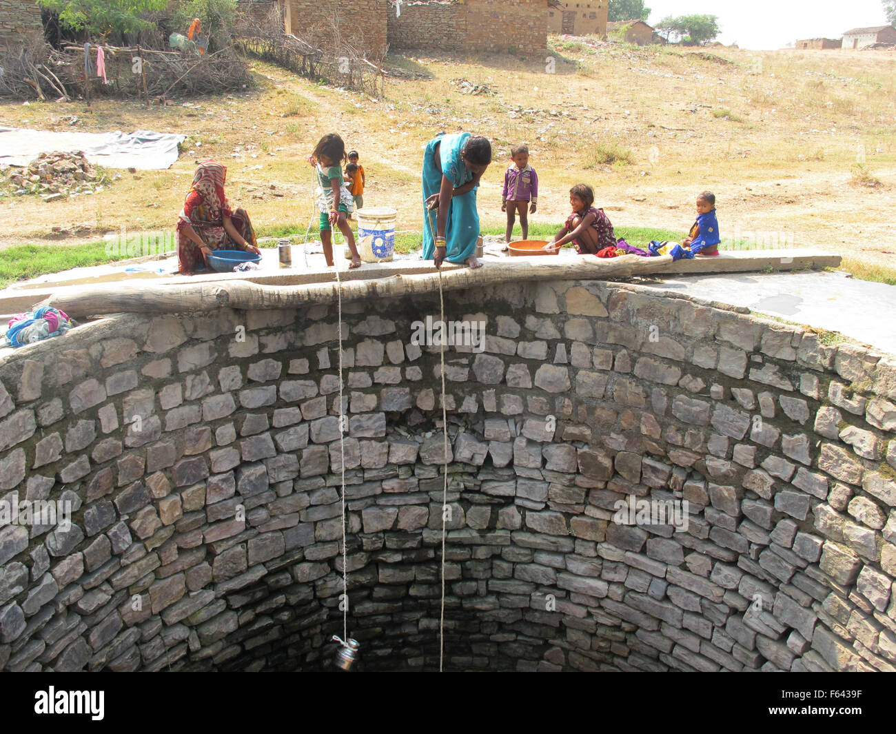 A woman with her daughter collects water at a well of the Tiger Reserve of the National Park Panna in India, 25 October 2015. Photo: Friederike Heine/dpa Stock Photo
