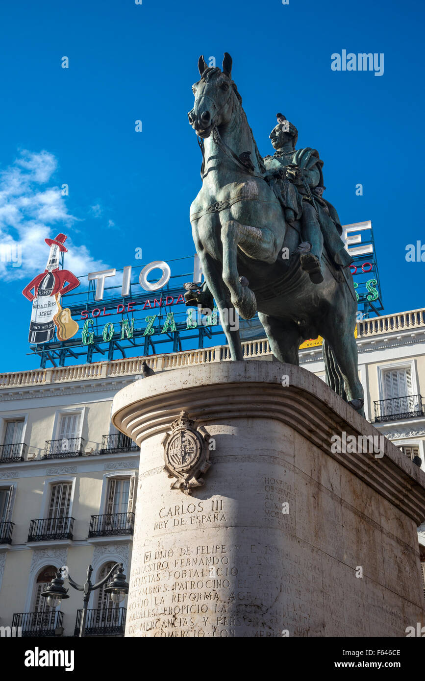 The famous Tio Pepe advertising sign looms over a statue of King Carlos III, in the Puerta del Sol,  Madrid, Spain. Stock Photo