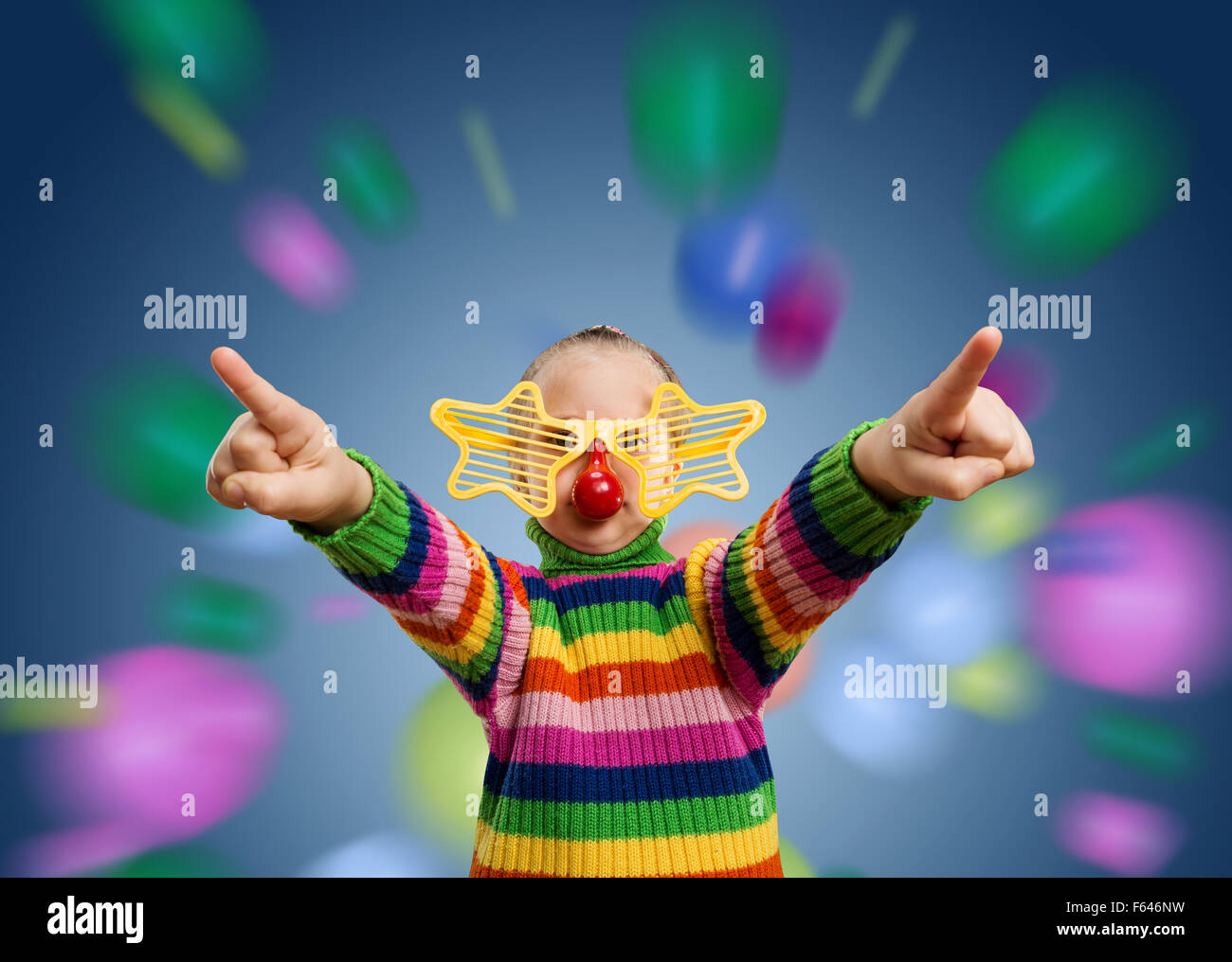 Little girl in funny starry party glasses against flying colorful balls Stock Photo