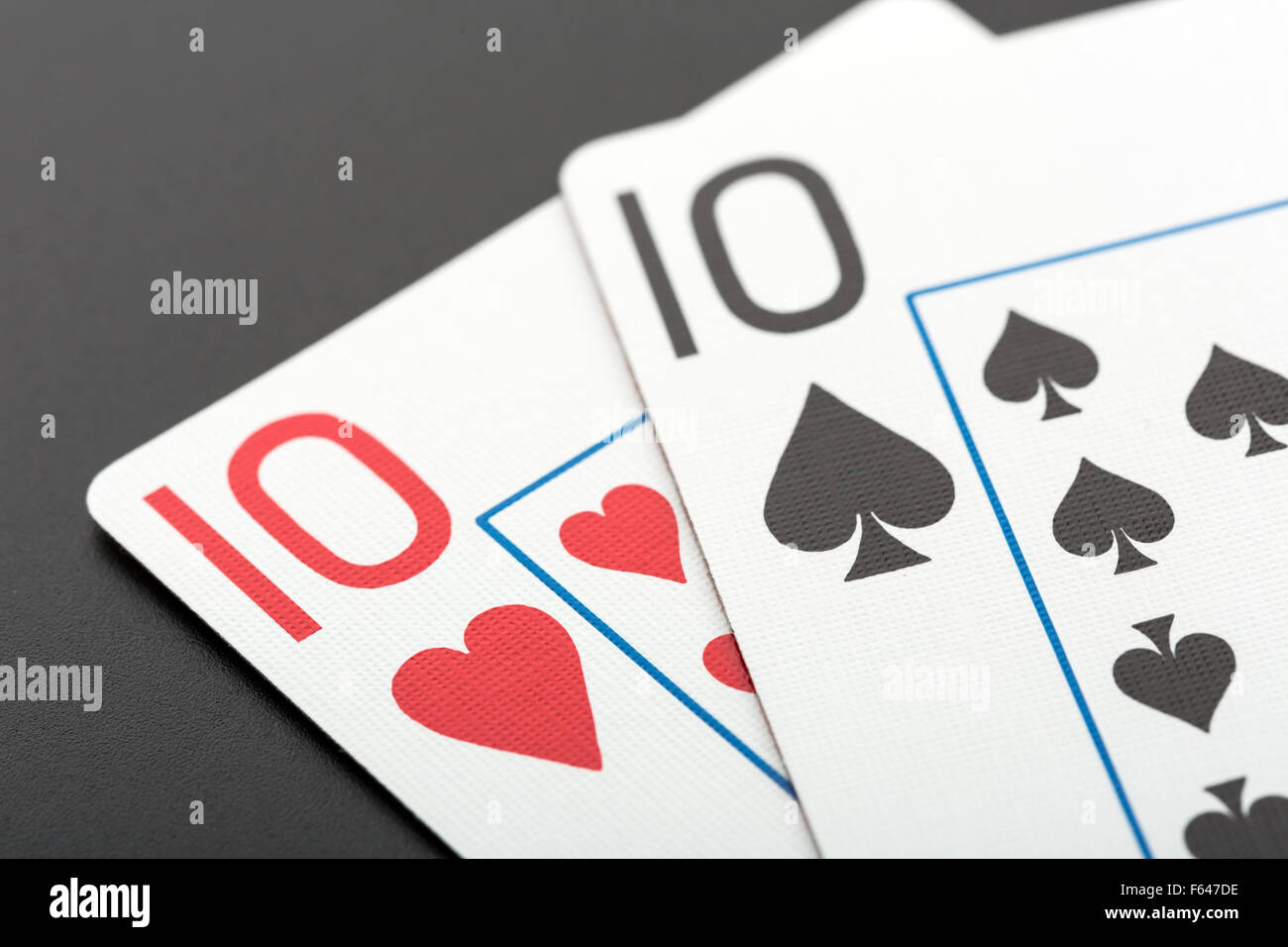 Two playing cards tens on grey background Stock Photo