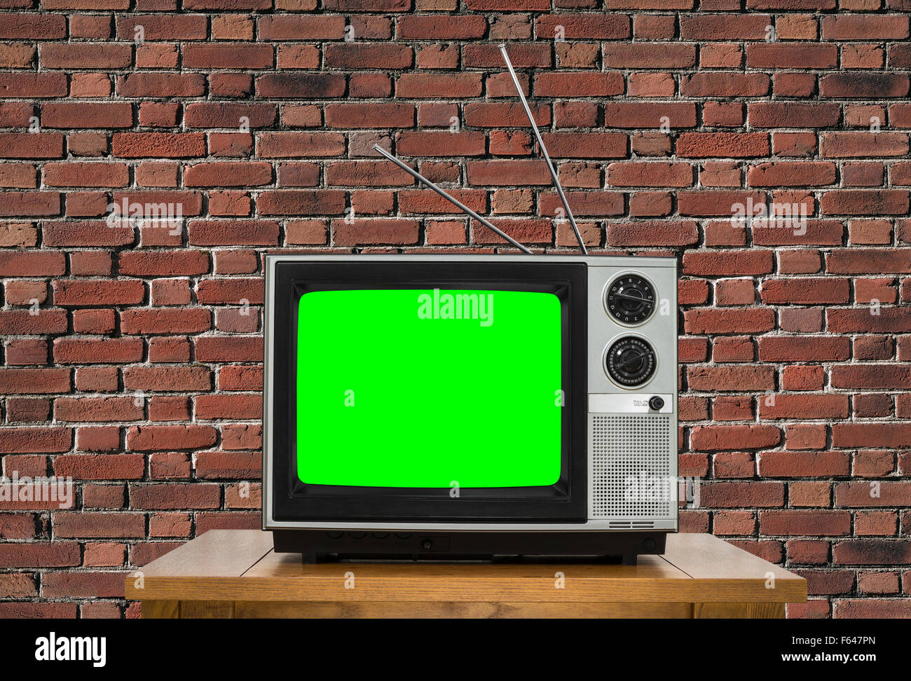 Old analogue television with chroma key green screen and brick wall. Stock Photo