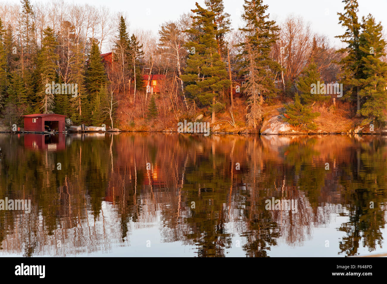 colourful reflects on a lake at twilight in Kenora, Ontario Stock Photo
