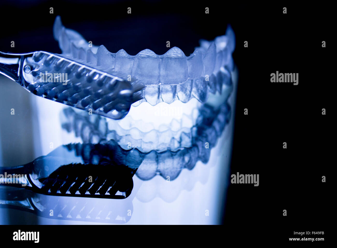 Dental retainers and toothbrush on dark background. Stock Photo