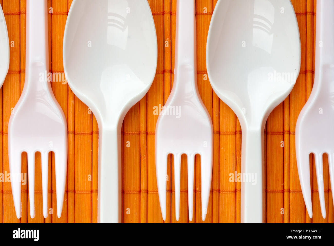 A row of plastic silverware. Spoons and forks Stock Photo Alamy