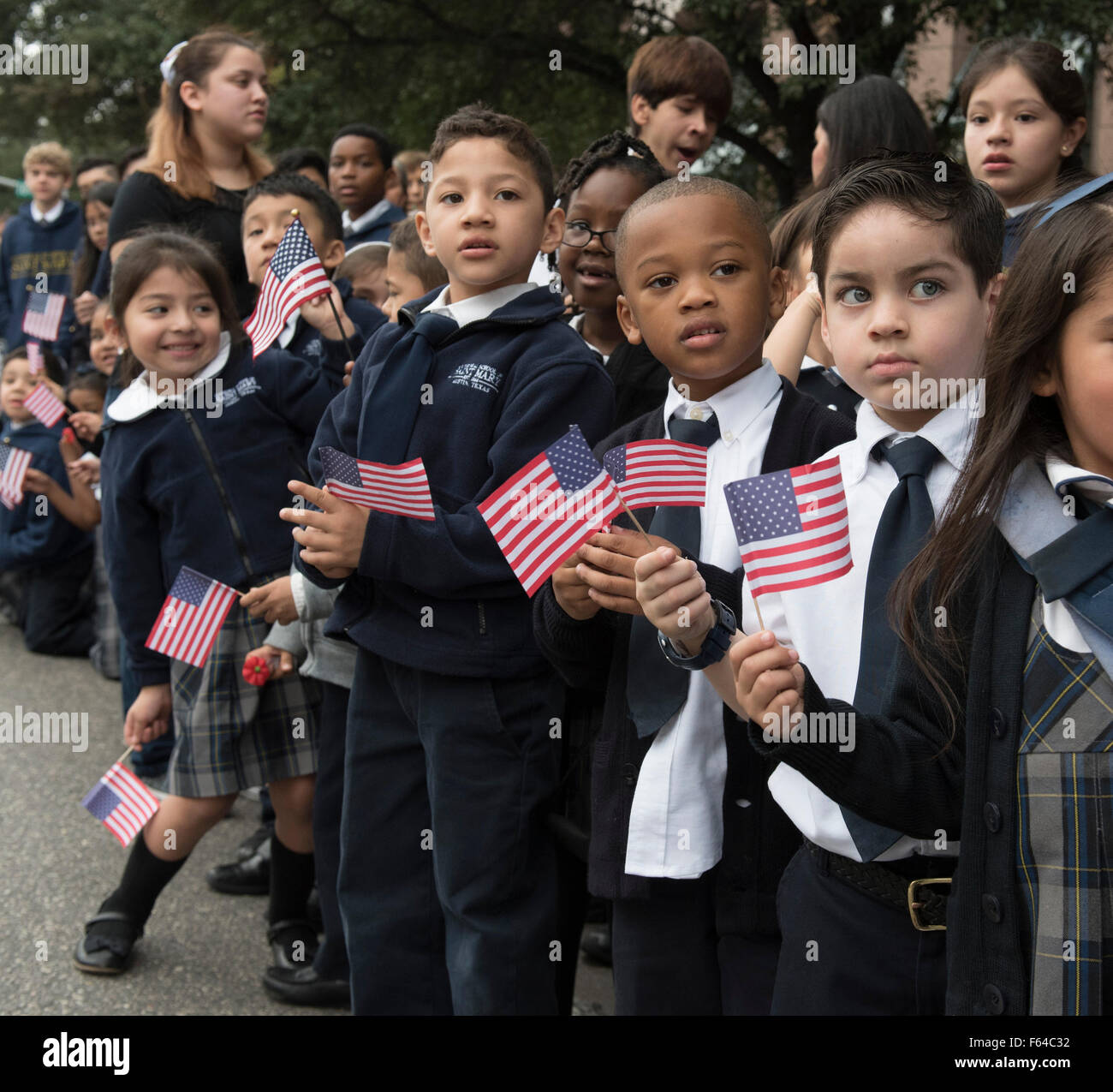 Austin, Texas USA November 11, 2015: Catholic schoolchildren from Saint Mary's in Austin cheer during the Veteran's Day parade up Congress Avenue and ceremony at the Texas Capitol. Several thousand Texans lined Congress Avenue to witness military heroes, marching bands and floats in the annual parade. Credit:  Bob Daemmrich/Alamy Live News Stock Photo