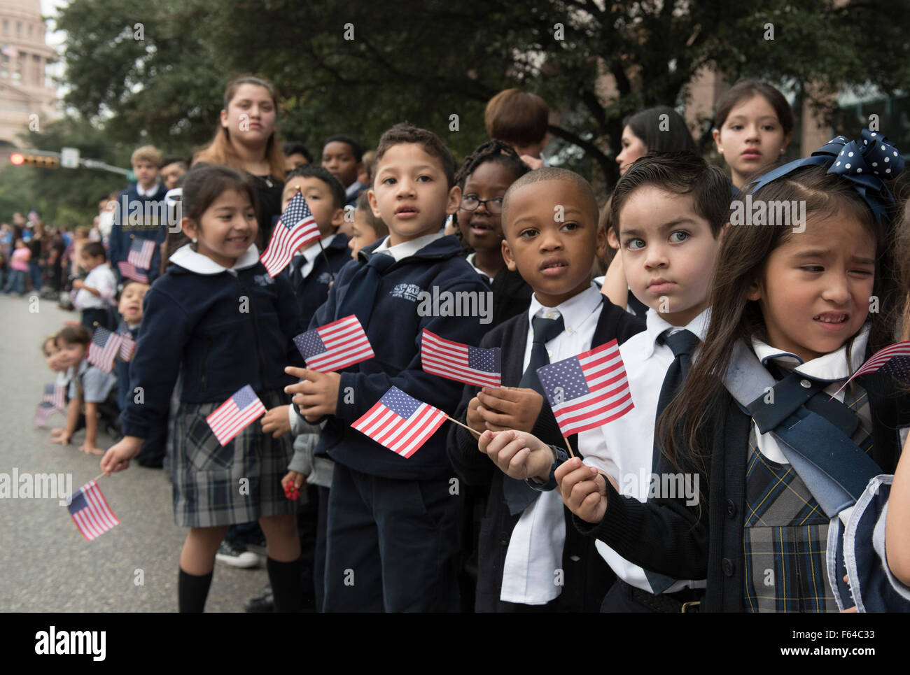 Austin, Texas USA November 11, 2015: Catholic schoolchildren from Saint Mary's in Austin cheer during the Veteran's Day parade up Congress Avenue and ceremony at the Texas Capitol. Several thousand Texans lined Congress Avenue to witness military heroes, marching bands and floats in the annual parade. Credit:  Bob Daemmrich/Alamy Live News Stock Photo
