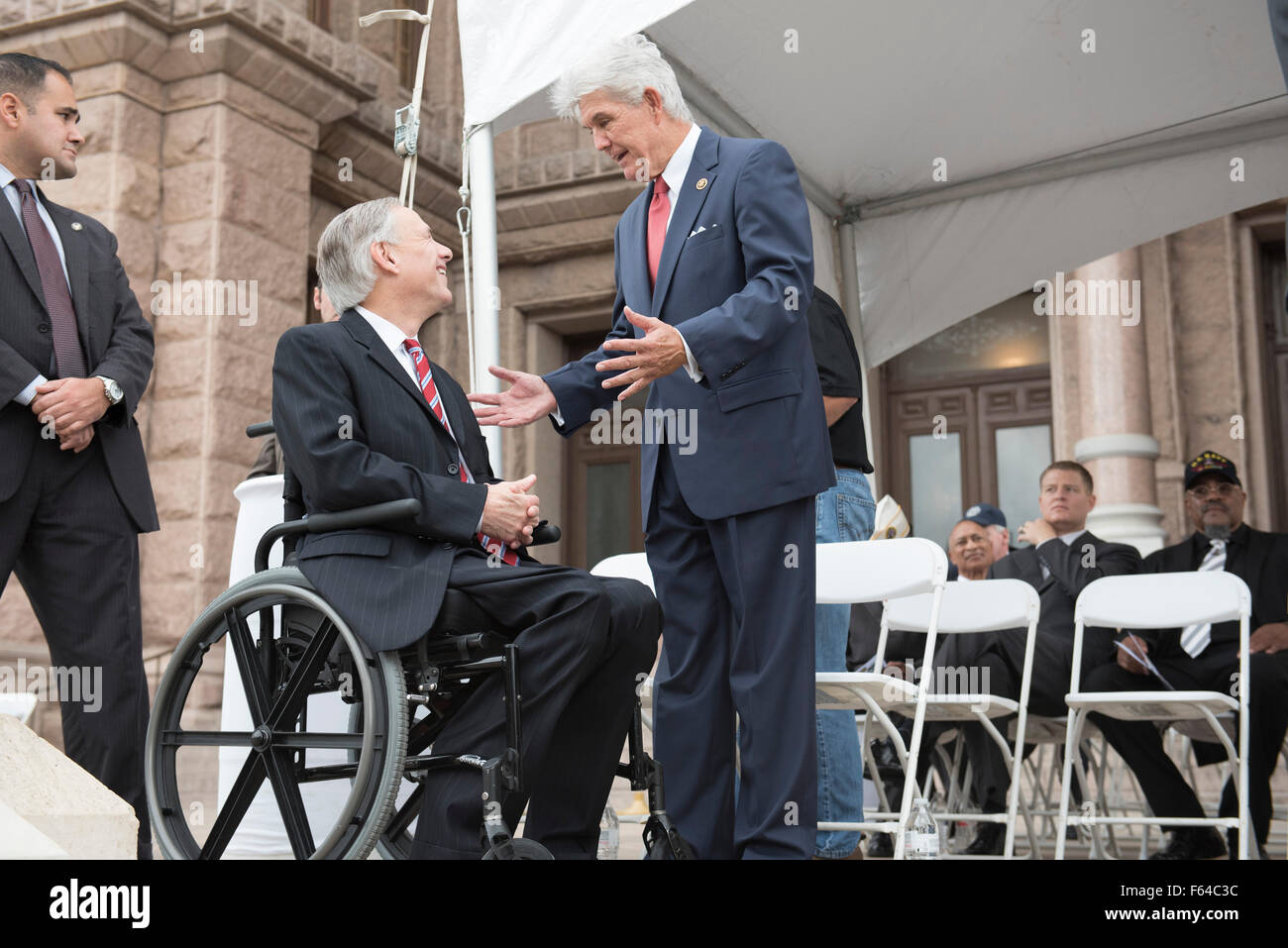 Austin, Texas USA November 11, 2015: Texas Gov. Greg Abbott (l) speaks with Congressman Roger Williams of Texas' 25th District during the Veteran's Day parade up Congress Avenue and ceremony at the Texas Capitol. Several thousand Texans lined Congress Avenue to witness military heroes, marching bands and floats in the annual parade. Credit:  Bob Daemmrich/Alamy Live News Stock Photo