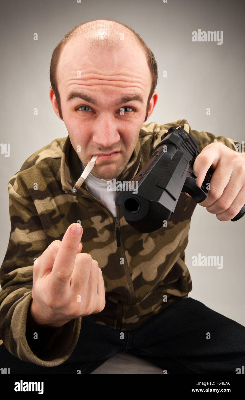 Smoking impudent bandit with gun attracting to himself Stock Photo