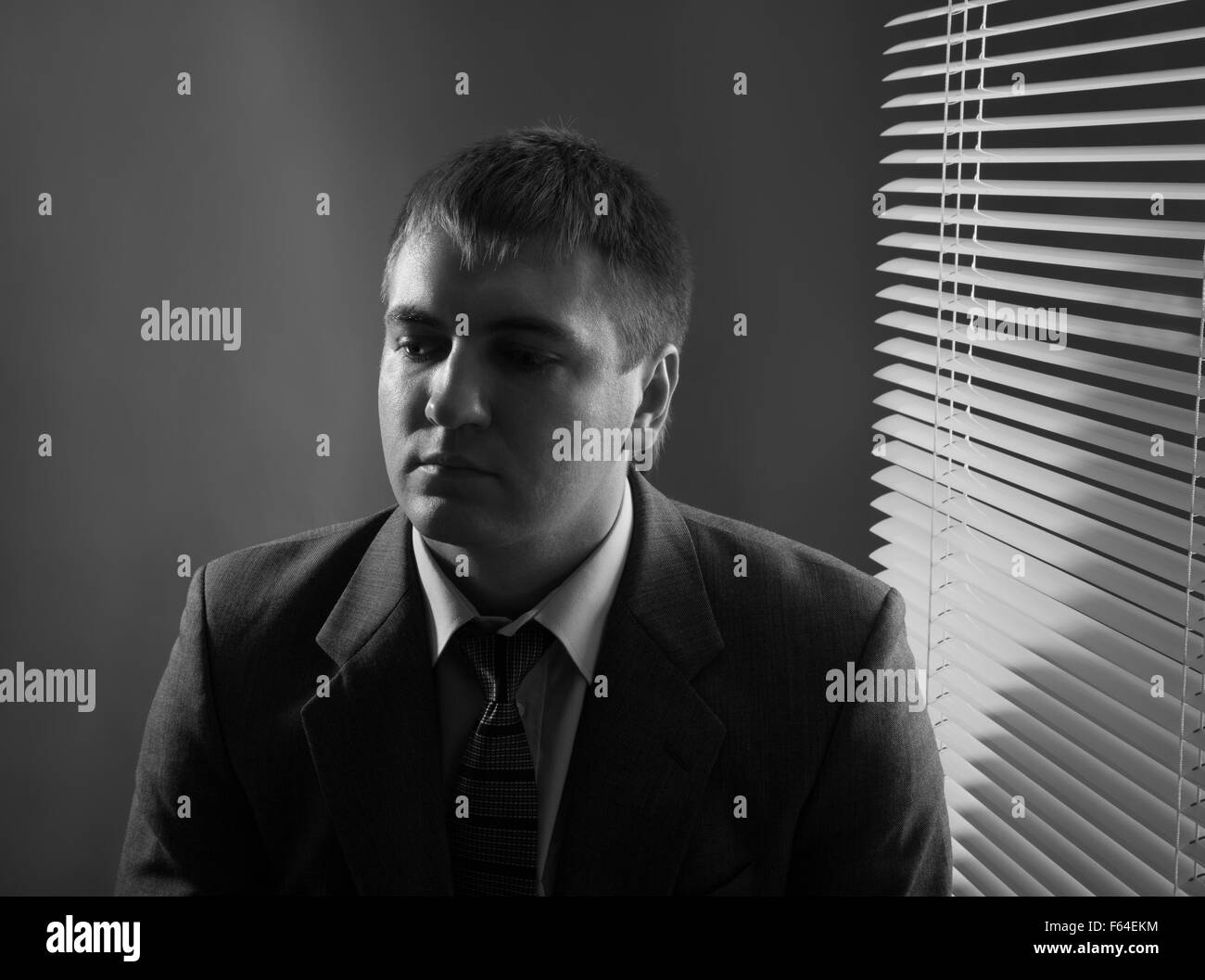 Tired office worker in a suit staring pensively Stock Photo