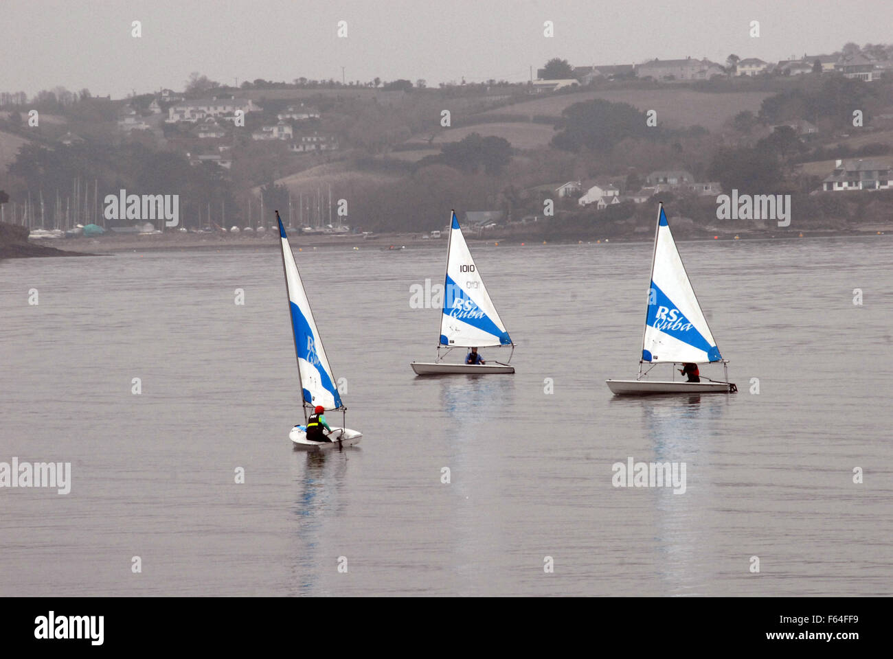 Three dingies take part in a sailing lesson in Carrick Roads off Mylor, Cornwall Stock Photo