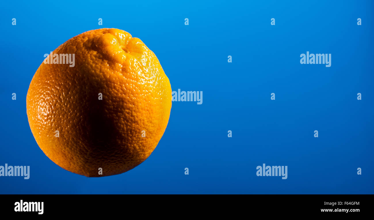 ORANGE on blue background, space for text layout, copyspace, text, font, fruit, food, vitamin C, colds, flu, flu infection, heal Stock Photo